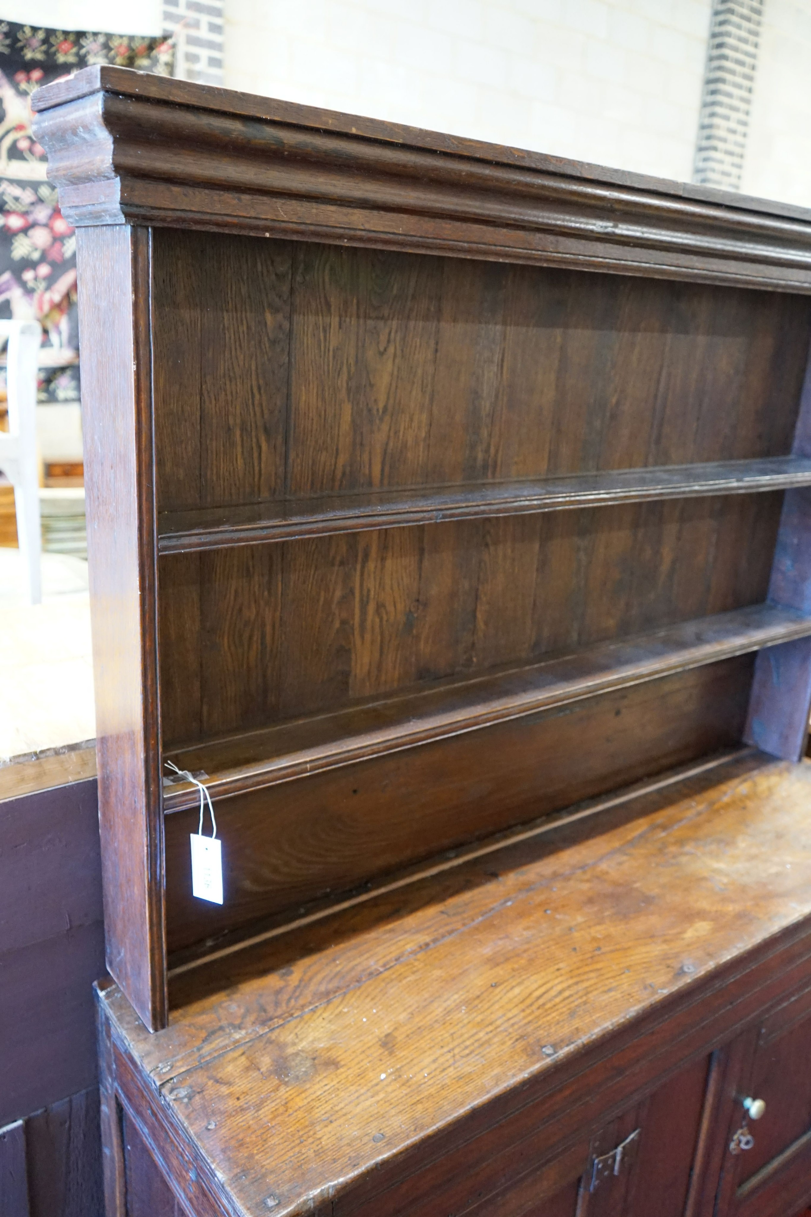 A 18th century and later small oak dresser with boarded rack, width 127cm depth 38cm height 166cm